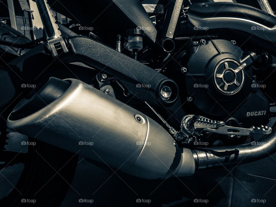 Motorcycle engine and exhaust pipe closeup.  