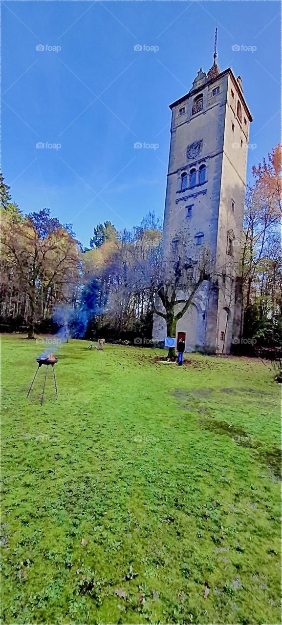 The tower at the entrance way of the former castle of „Steinach“ in „Bavaria“ and parts of the apple orchard and lush green grass in the garden. 2022. Hypnotic Productions