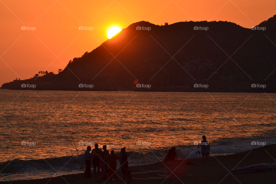 Silhouette of people at beach during sunset