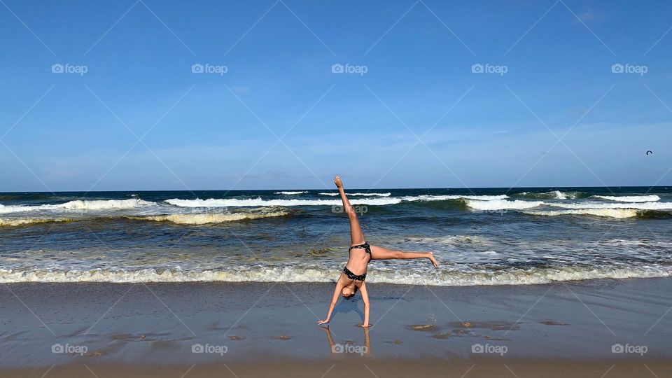 Child doing acrobatics on the beach