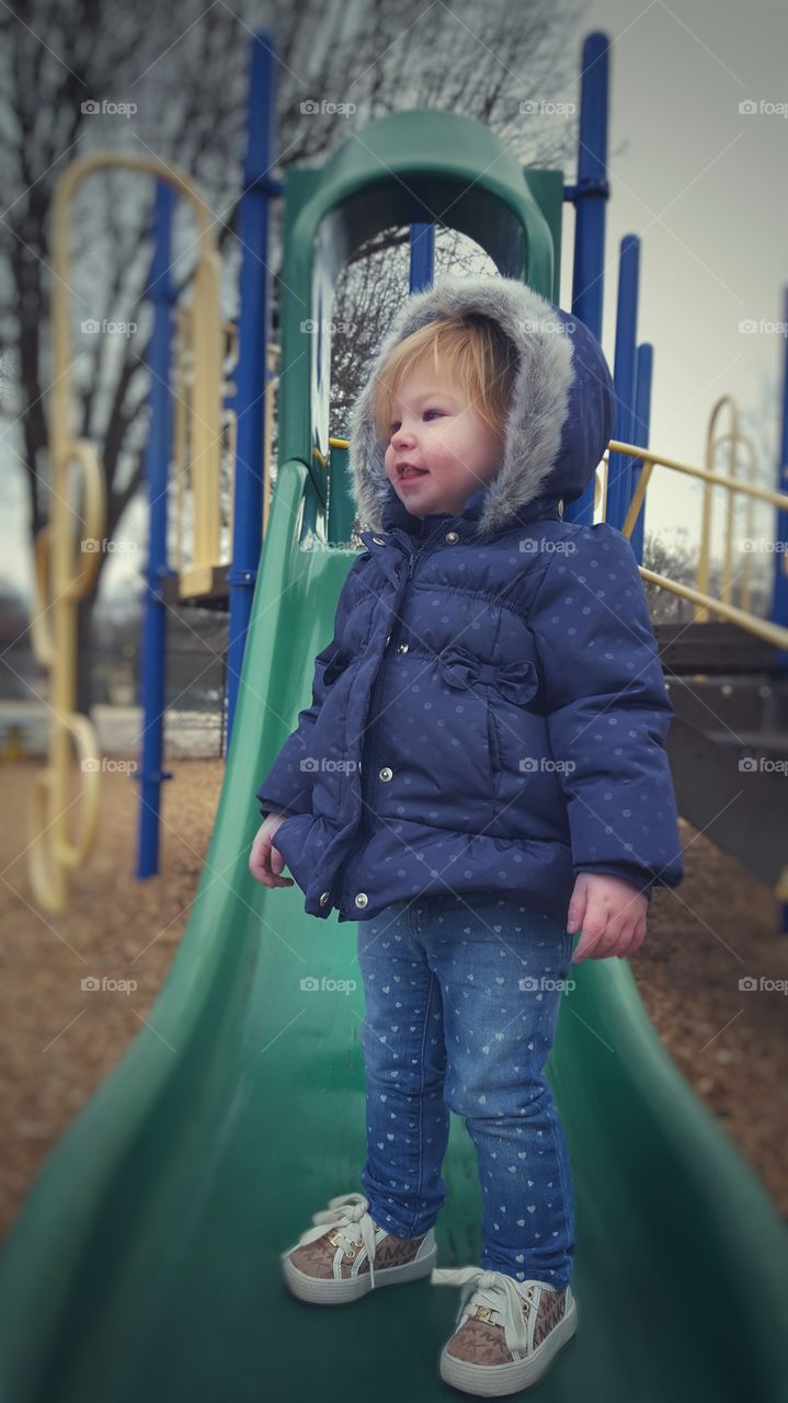 Small girl standing on slide