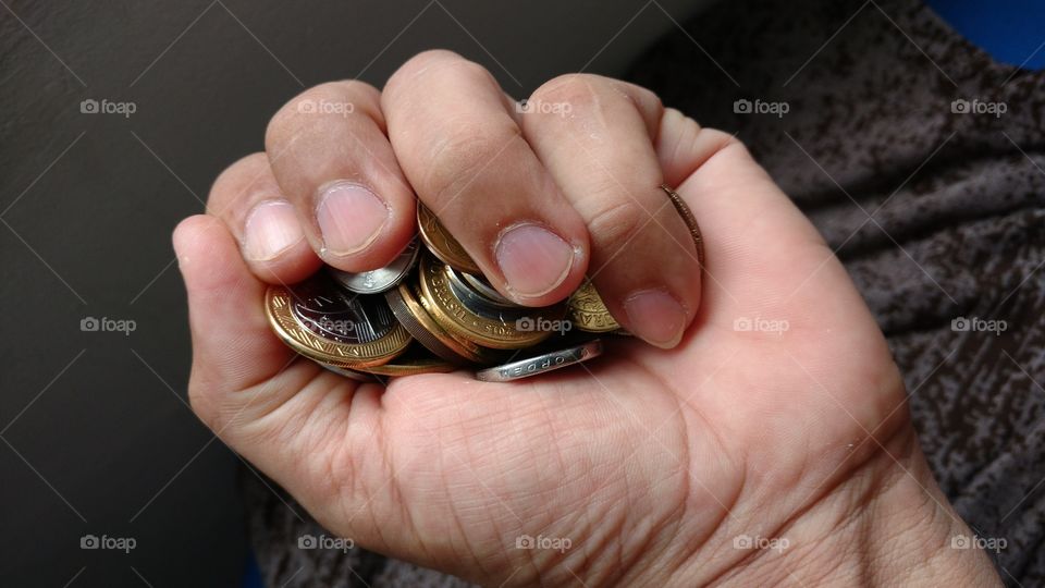 Mão segurando moedas.