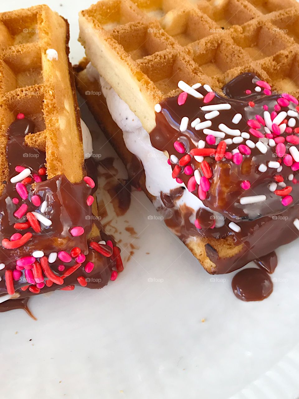 Two waffle ice cream sandwiches with sprinkles
