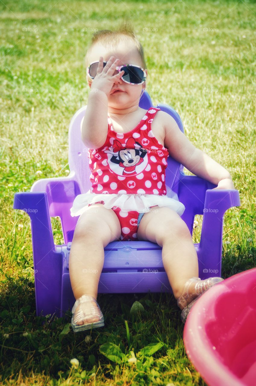 Sassy baby lounging by the pool.