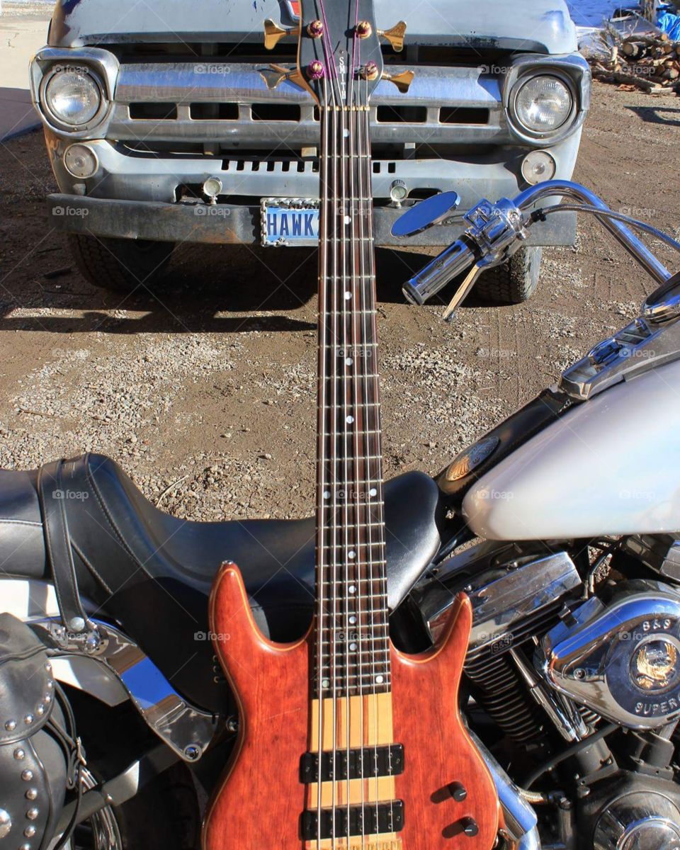 6 string hammer bass on a Harley with steampunk truck in the background.