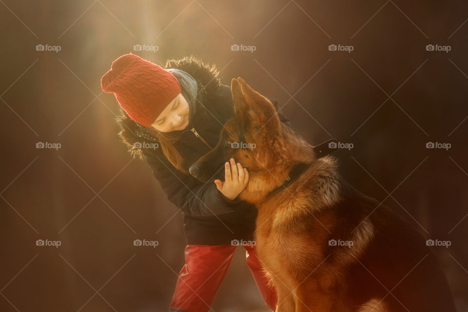 Girl portrait with German shepherd puppy in a spring forest at sunset 