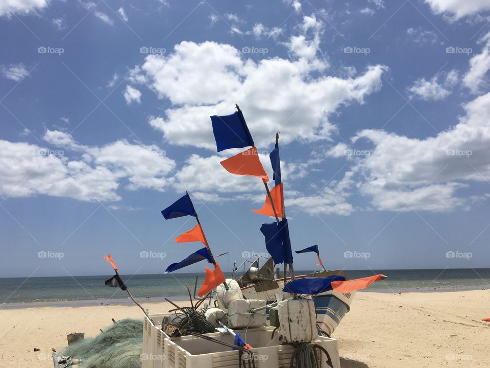 Blue and orange fishermen flags on beach