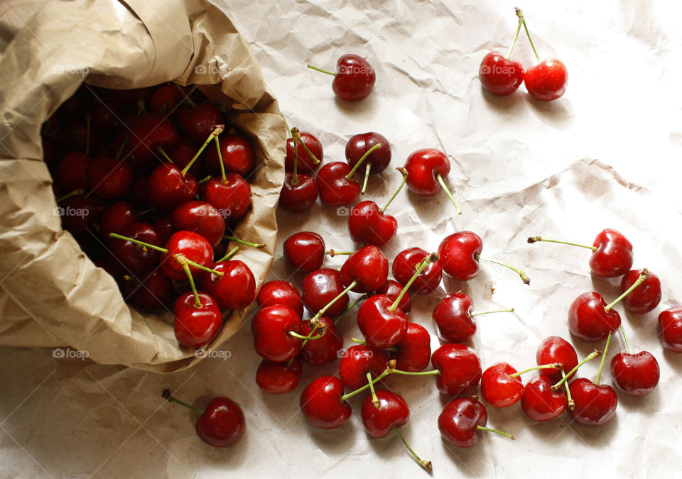 Cherries in a paper bag on a paper background