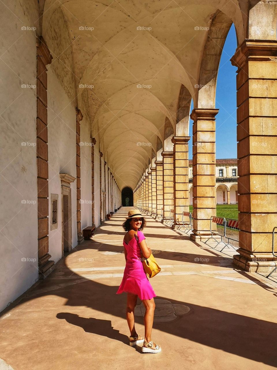 woman with straw hat wears a fuchsia summer mini dress