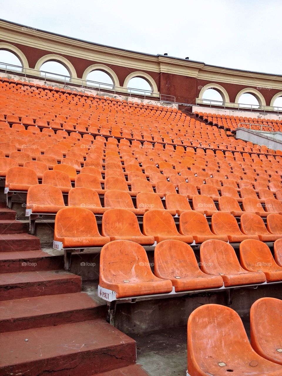Seating rows in a stadium with weathered chairs