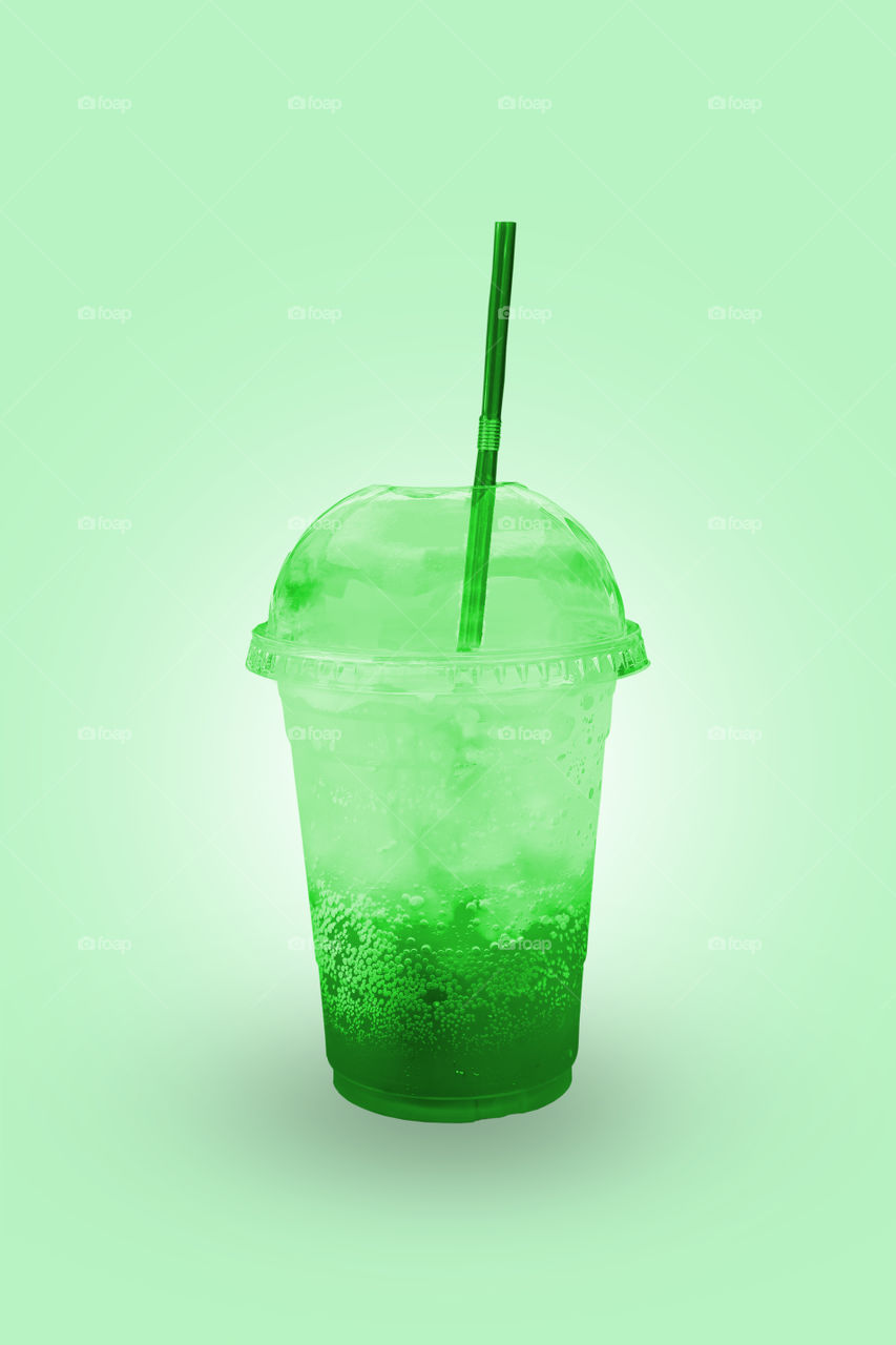 Green juice with ice in a plastic glass with clipping path.