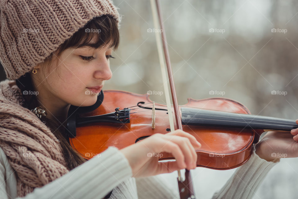 Teenage girl portrait with violin in winter park