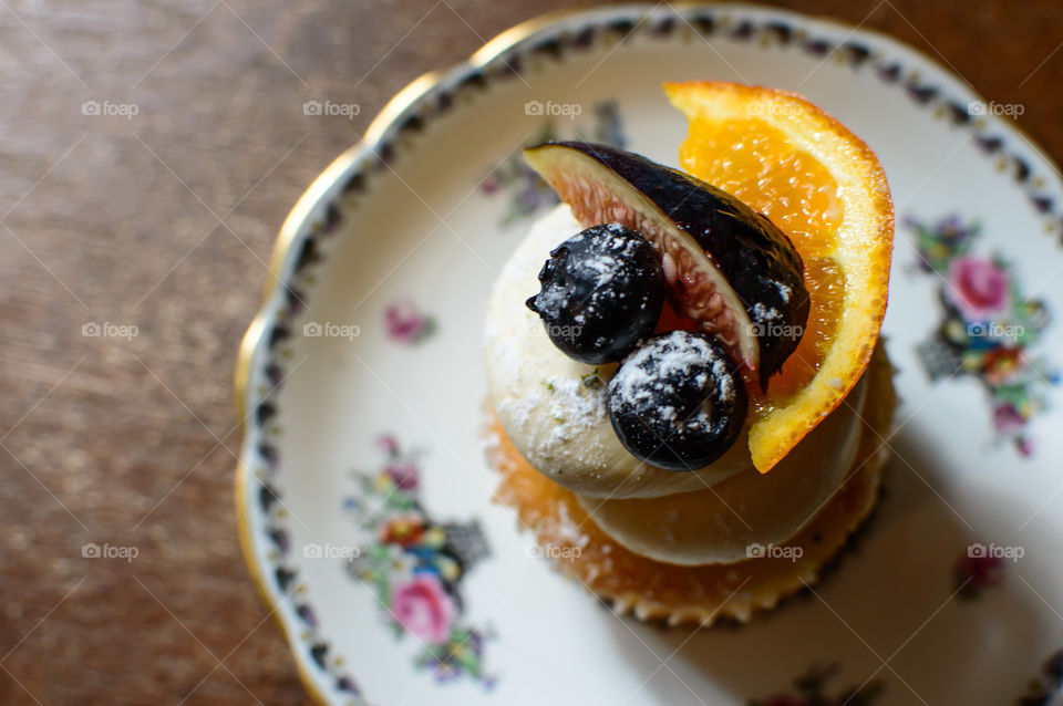 Closeup of fresh autumn cupcake with fig and blueberry on plate