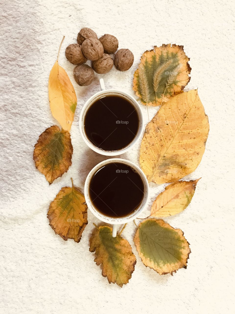 The two white cups of coffee in the autumn vibes.