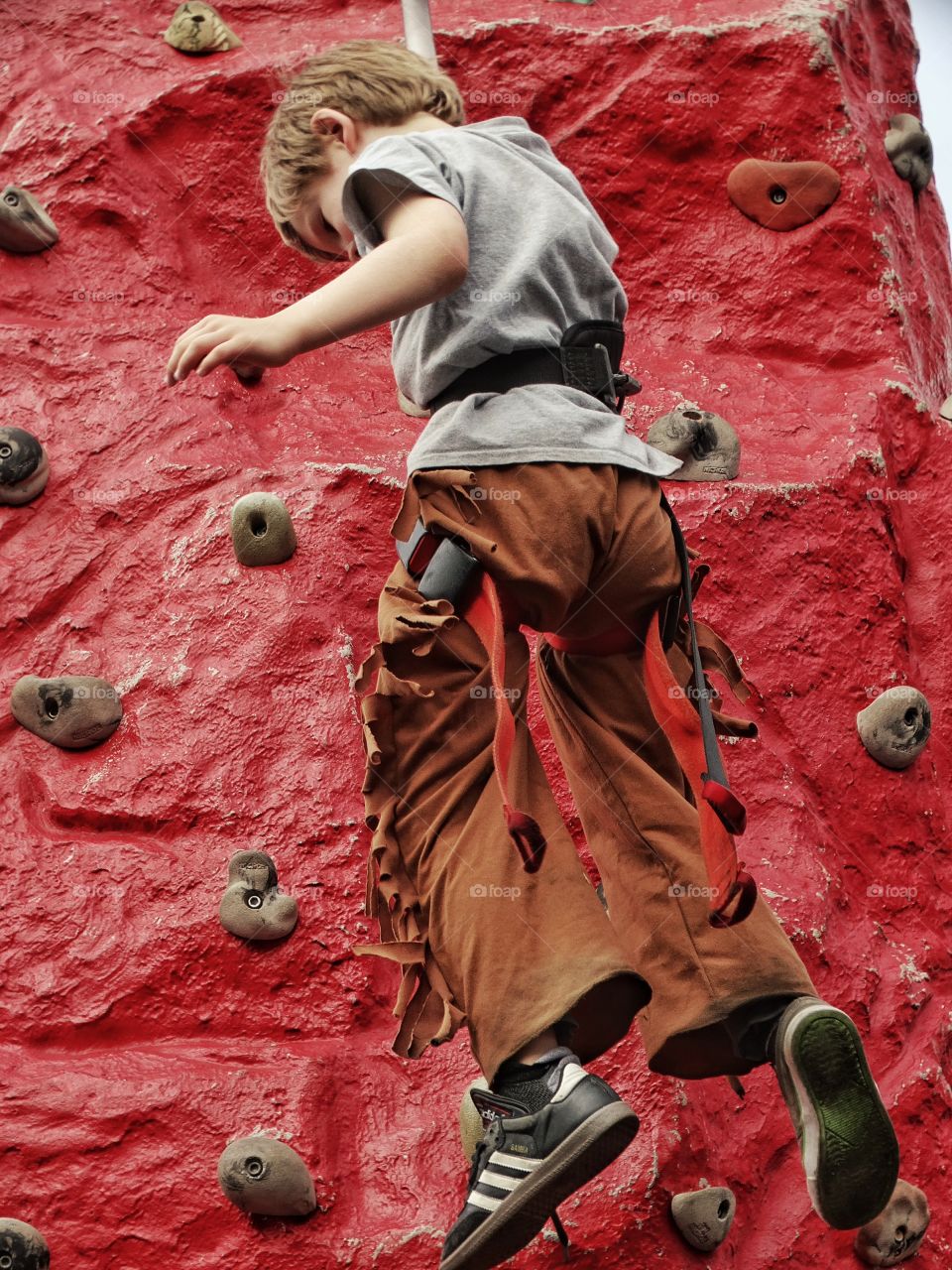 Boy Climbing A Rock Wall

