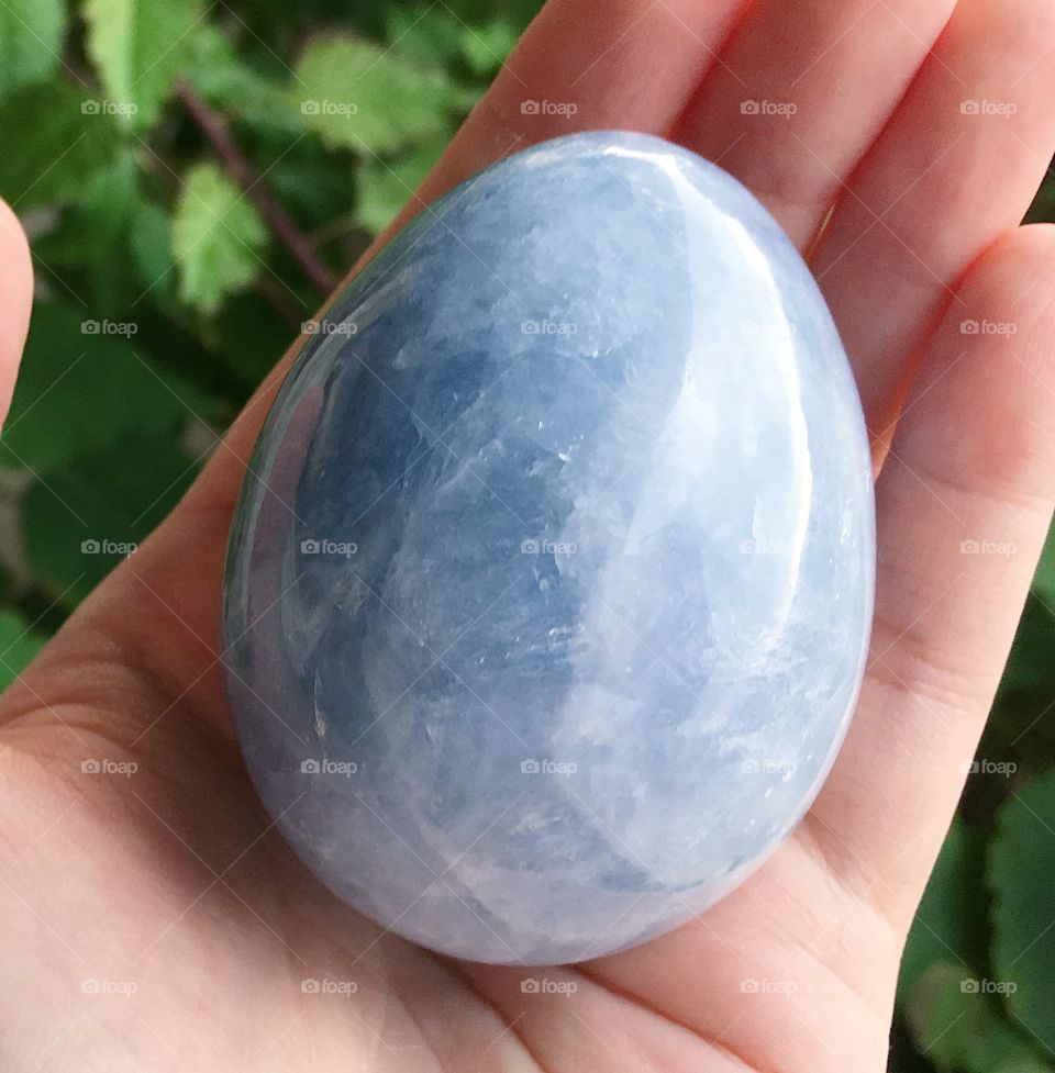 A polished blue egg-shaped celestite crystal display piece.