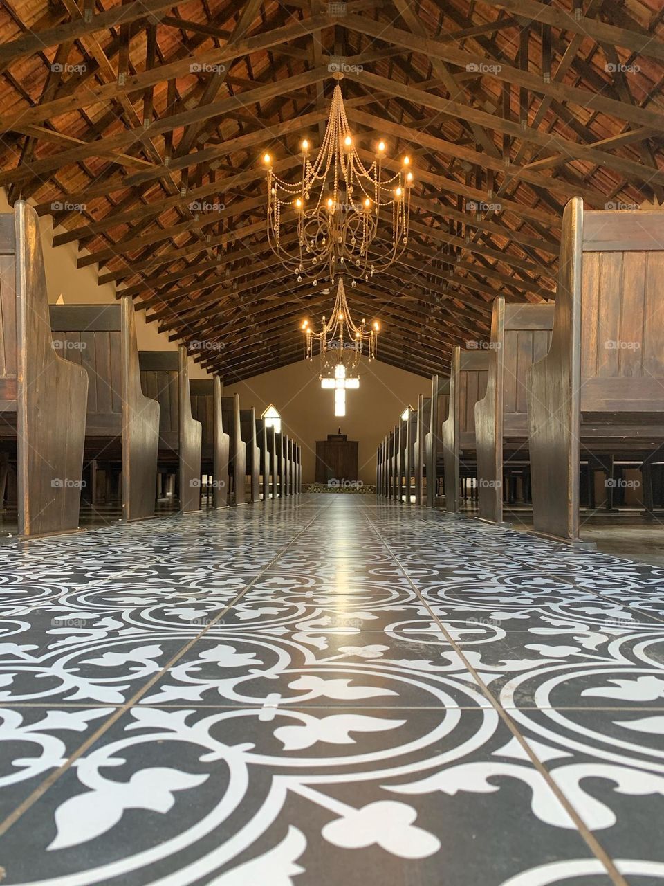 Moroccan styled chapel with wooden pews and a wooden roof with metallic chandeliers 