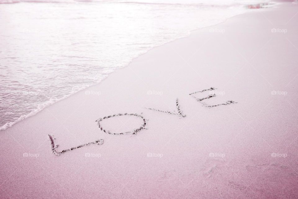 Word love on sandy beach 