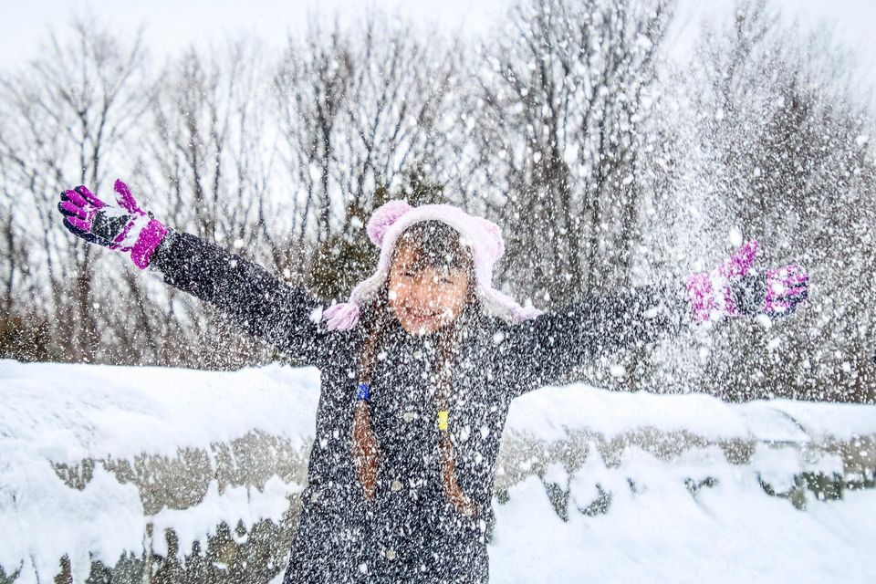 Happy little girl is playing in the snow