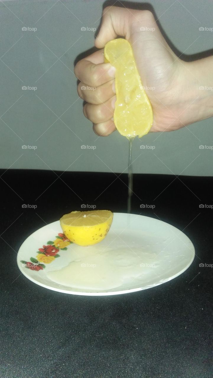   
Hand squeezing half lemon