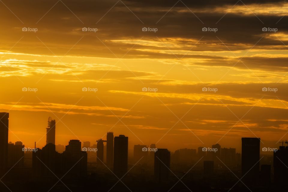 Orange twilight over silhouette scene of skyscraper in Bangkok Thailand