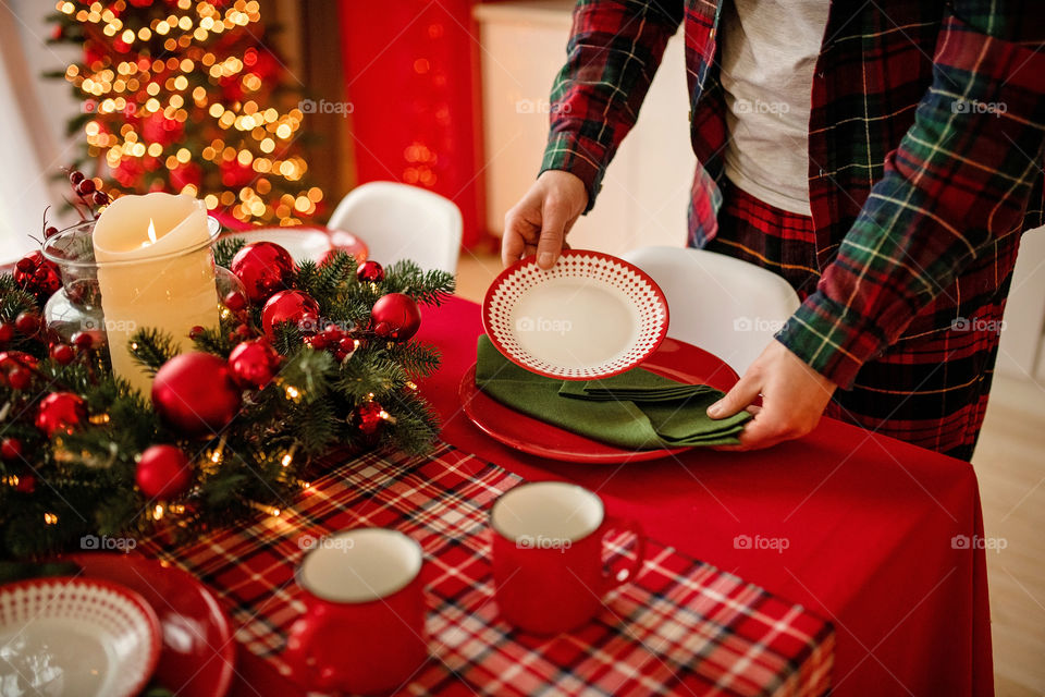 man sets a beautiful decorated winter table for a festive dinner.  Merry Christmas and Happy New Year.