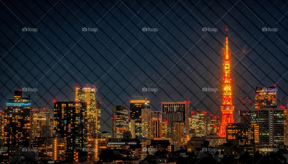 Tokyo tower on city light scape behind window 