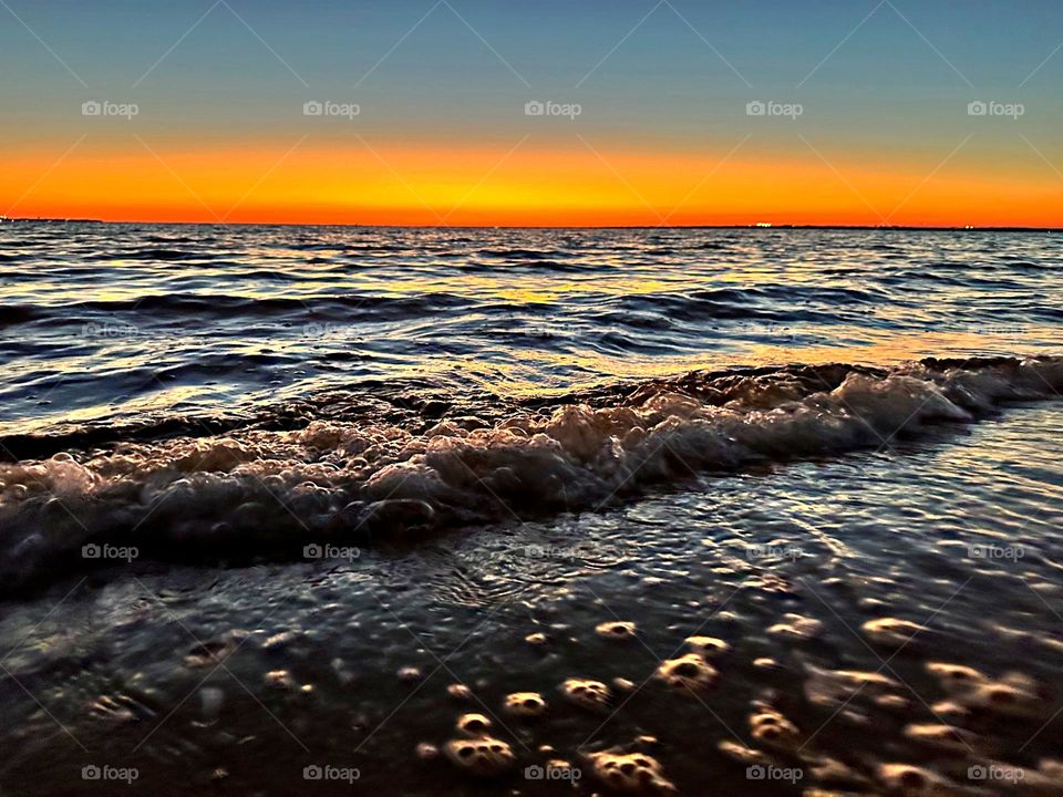 A breathtaking and radiant sunset which colors the waves iridescent, often towers and collides the shore with great force. The impact of the waves against the coastline created a stunning display of energy and motion