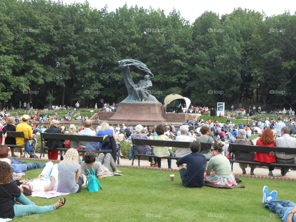 Recital of Frederick Chopin piano music at summer concert by the Statue of Frederick Chopin in the Royal Lazienki Park, Warsaw