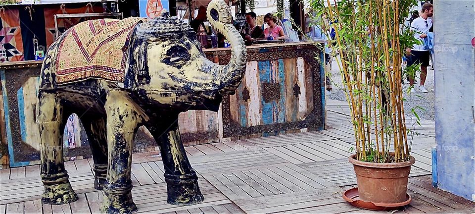 This wooden elephant statue is one of many handcrafted items for sale at the “Tollwood” summer festival in “Munich”, Bavaria. It presents music as well as a large market with folkloric arts and crafts from around the World. 2024. Hypnotic Productions