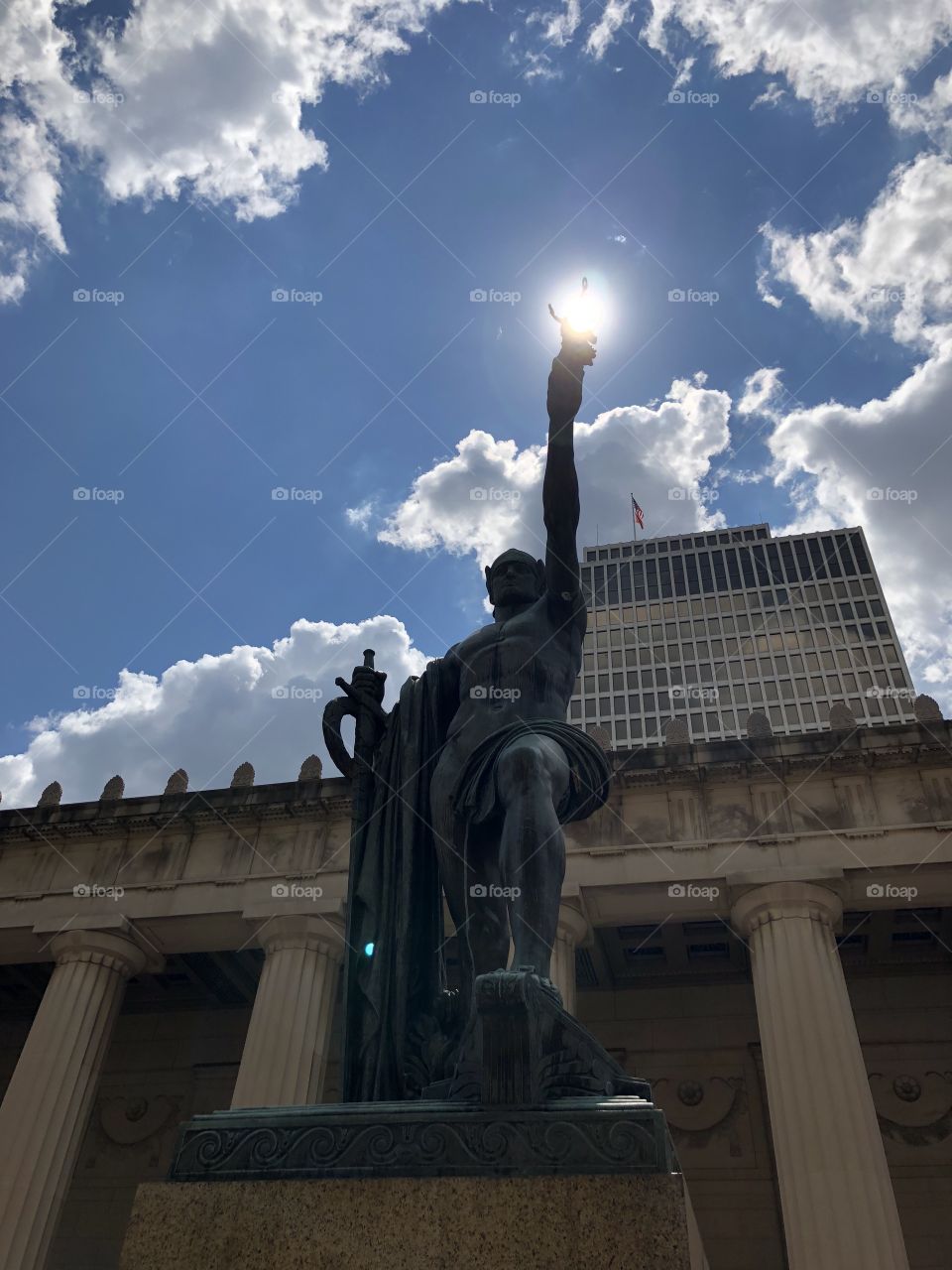 A replica Greek statue stands in the open plaza in Nashville, confidently holding the light of the sun in his hand, purporting his power towards an accredited and successful lifetime.