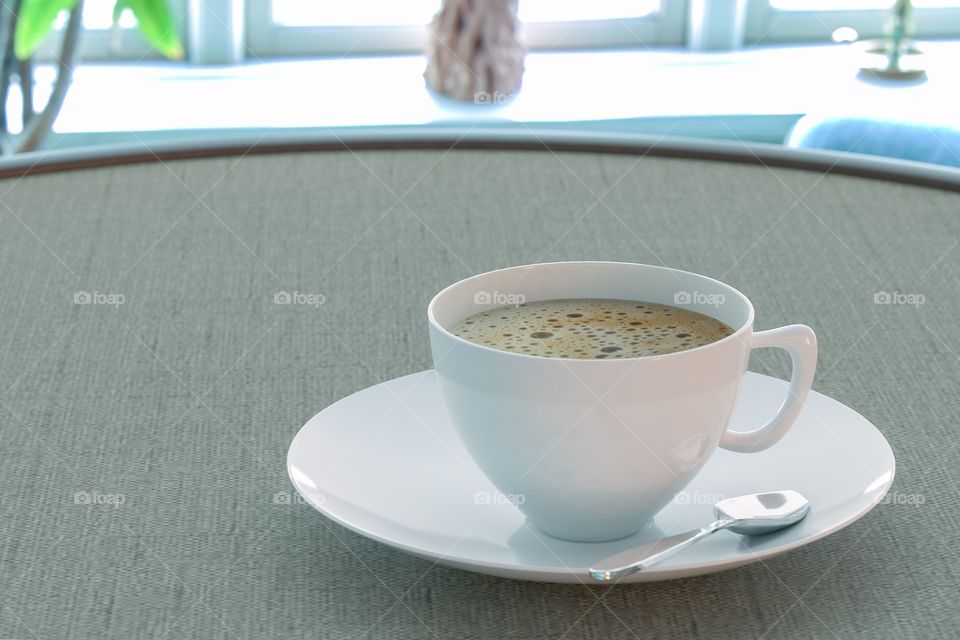 Coffee in a cup on the table by the window