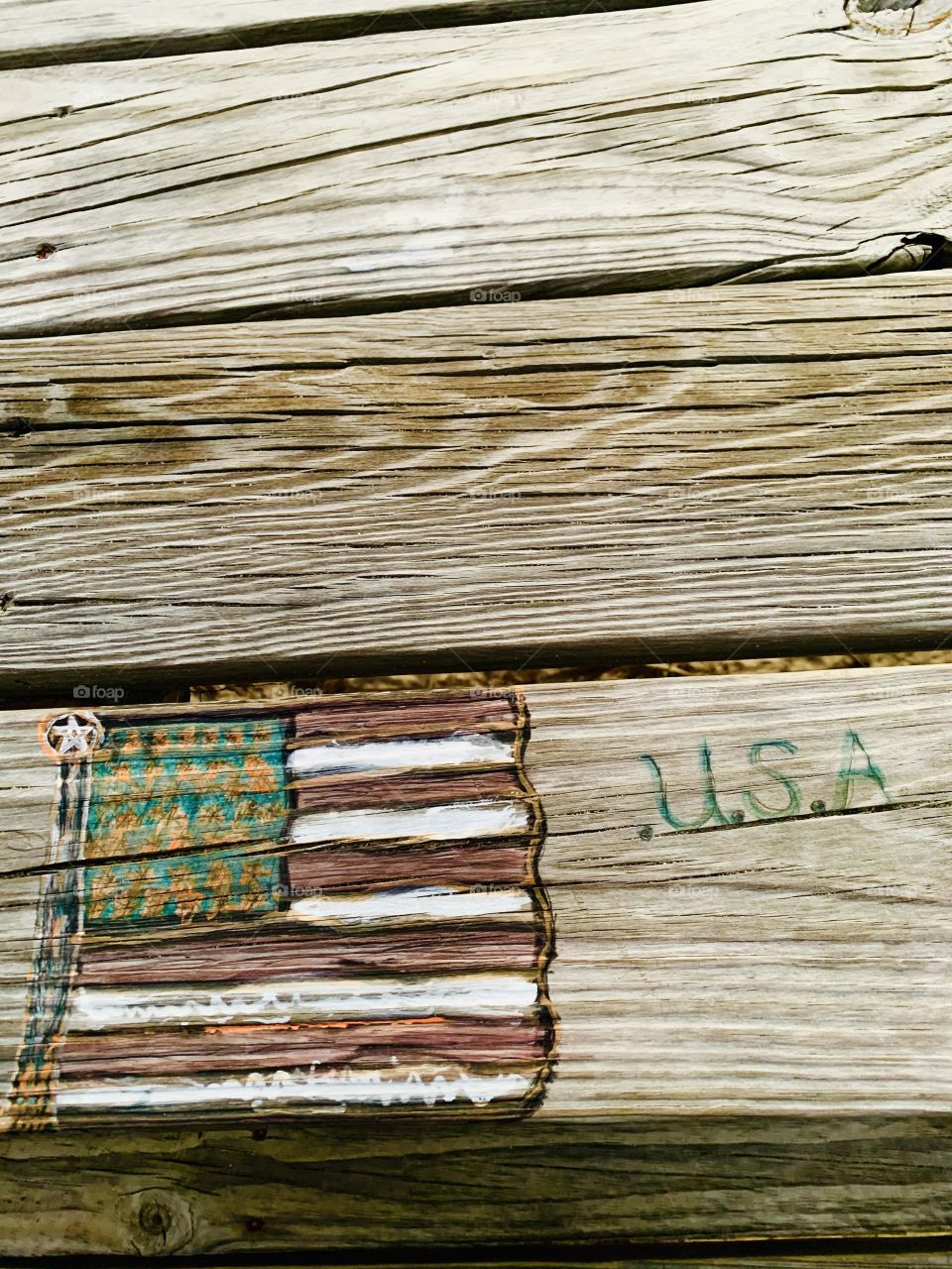 Someone carved these designs in a wooden picnic table. Carving is the act of fashioning or producing by cutting into or shaping solid material, as wood. a carved design or figure.