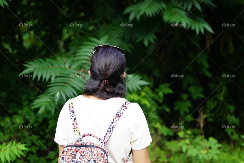 Woman peering into the woods