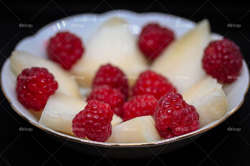 red berries and slices of a melon at the plates