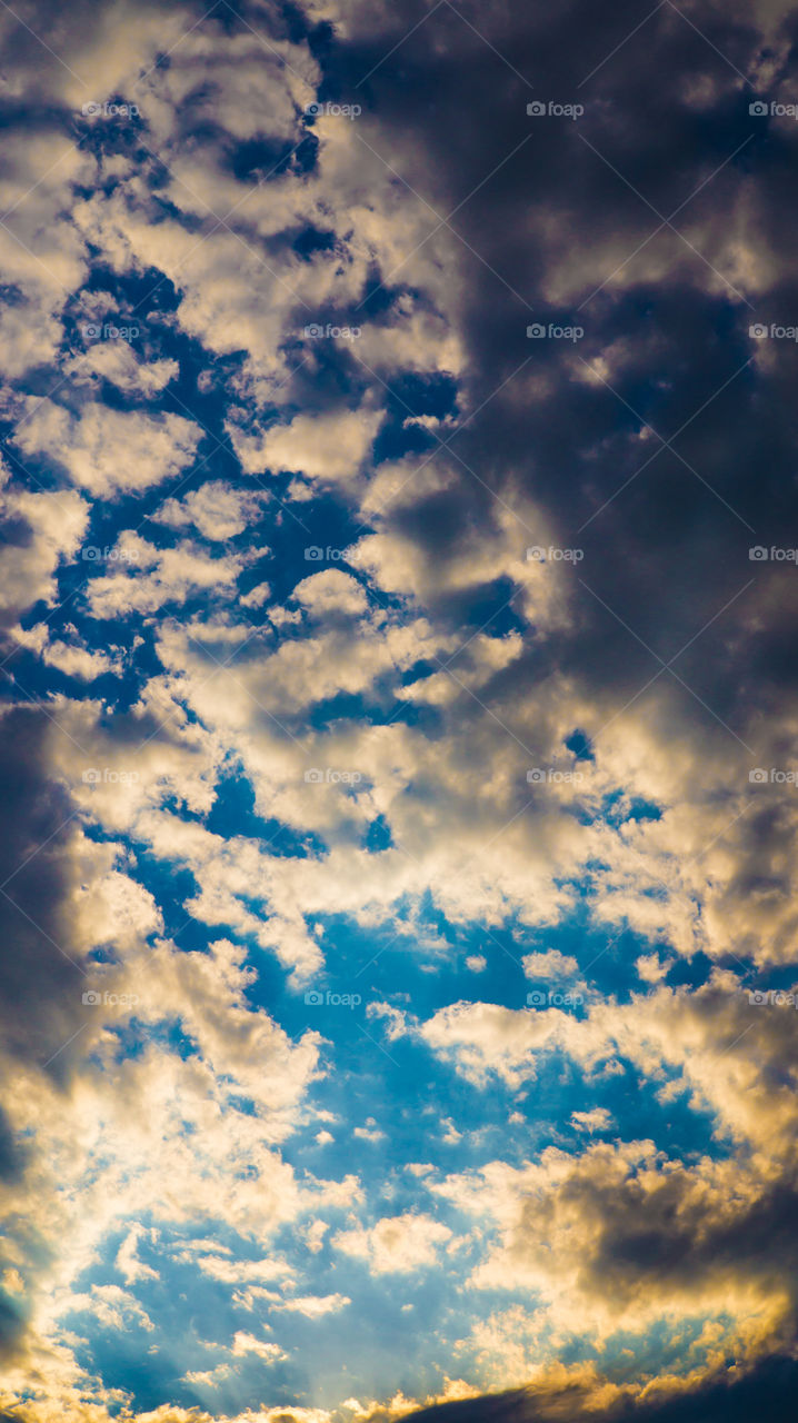 Large clouds float across the sunset sky like sails.