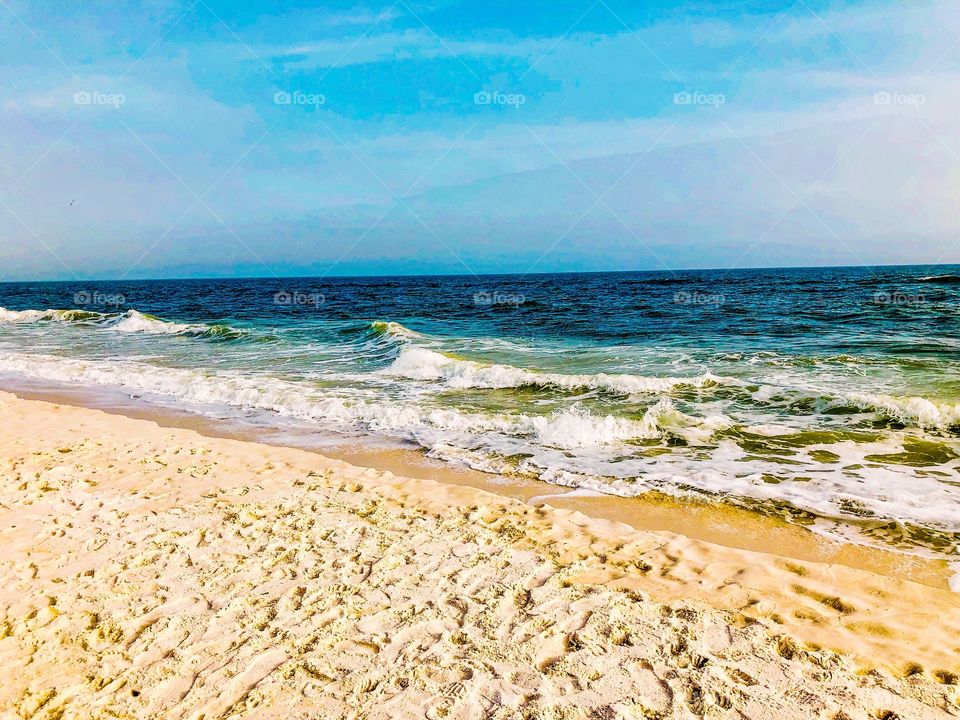 Seascape with sand on beach with waves