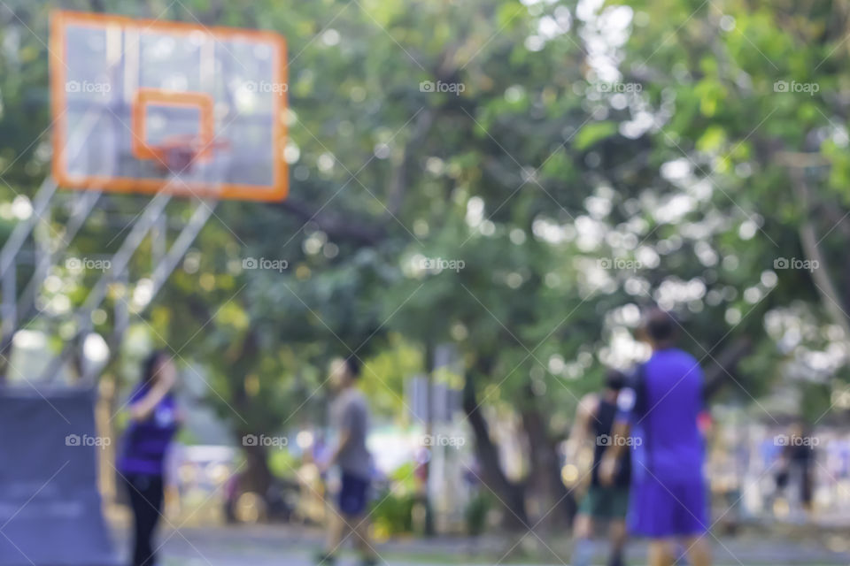 Blurry image of elderly men and women playing basketball in the morning.