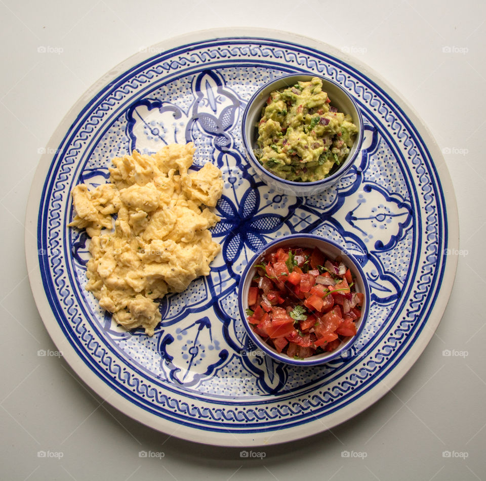 Spiced up breakfast with scrambled eggs and guacamole and salsa 