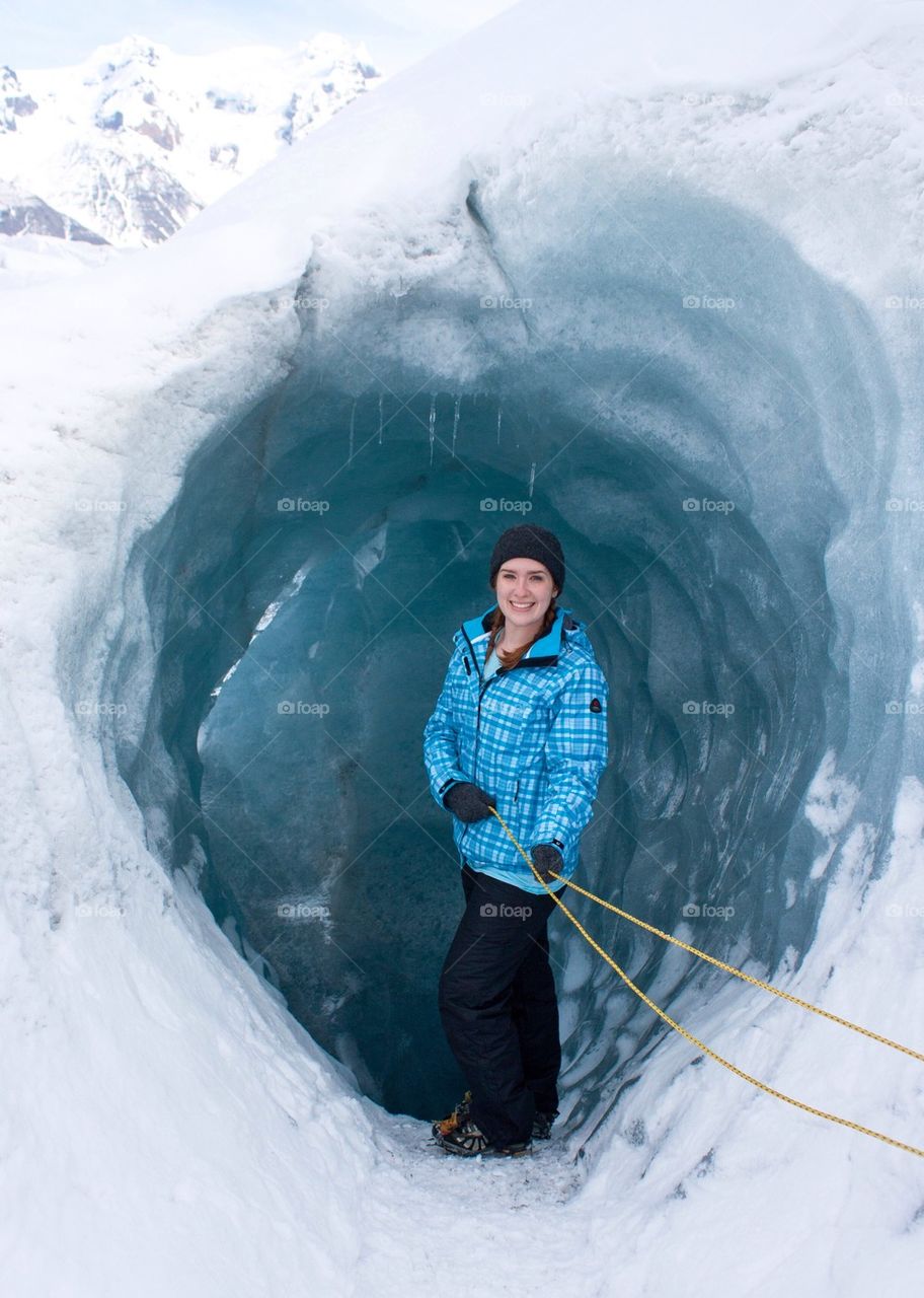 Woman posing by ice cave 