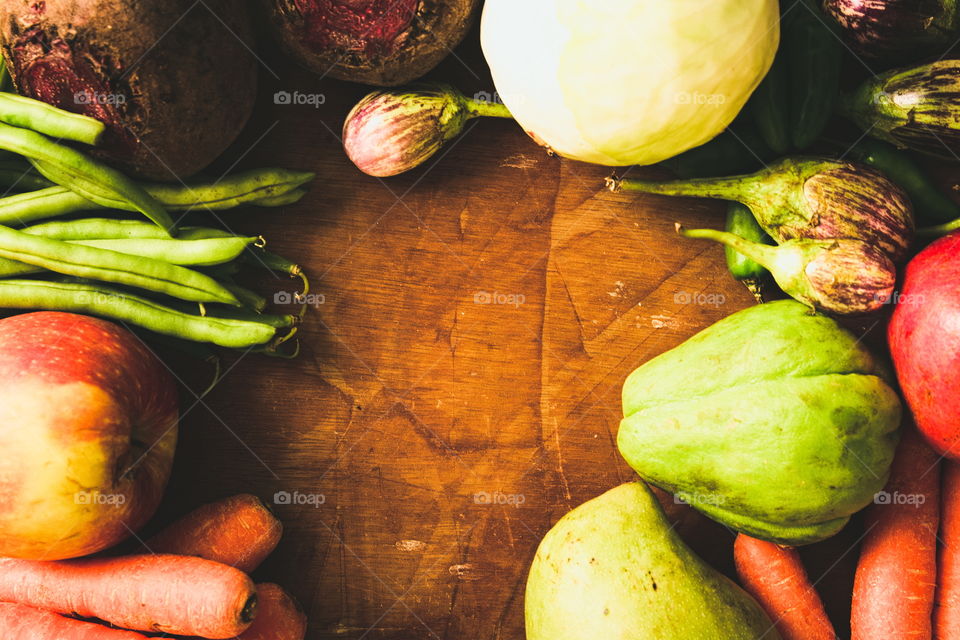 Fresh fruits and vegetables placed on a wooden board