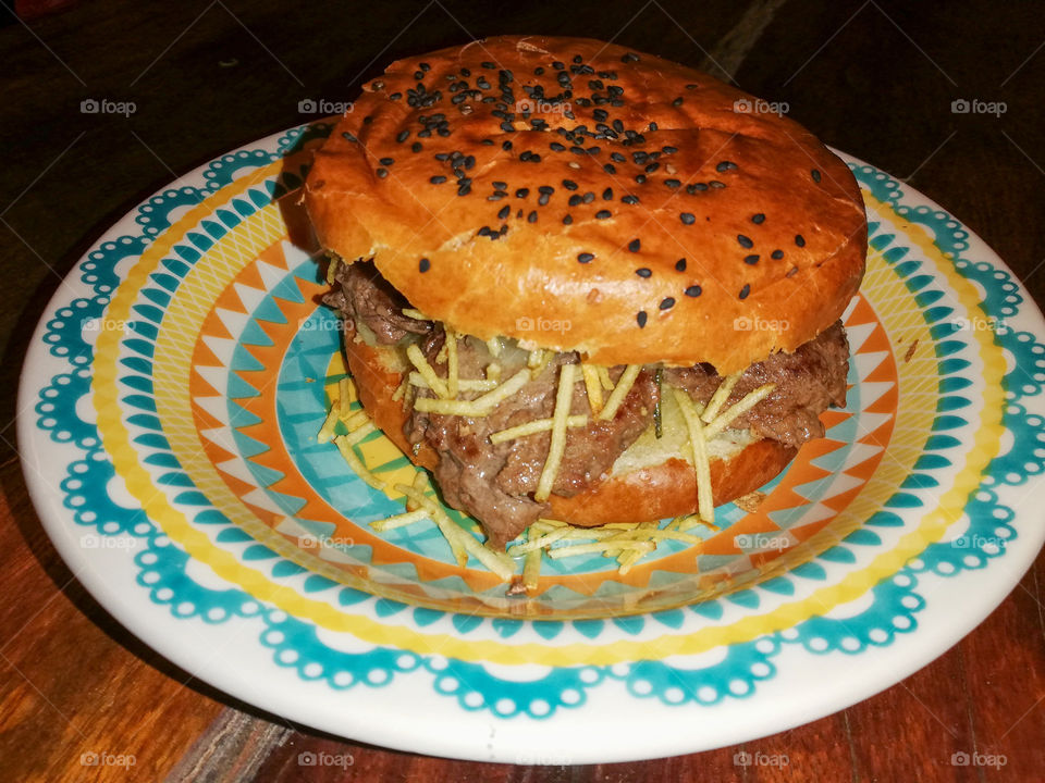 Hamburger with pork sausage. With homemade bread and chips . Hamburger de linguiça. 