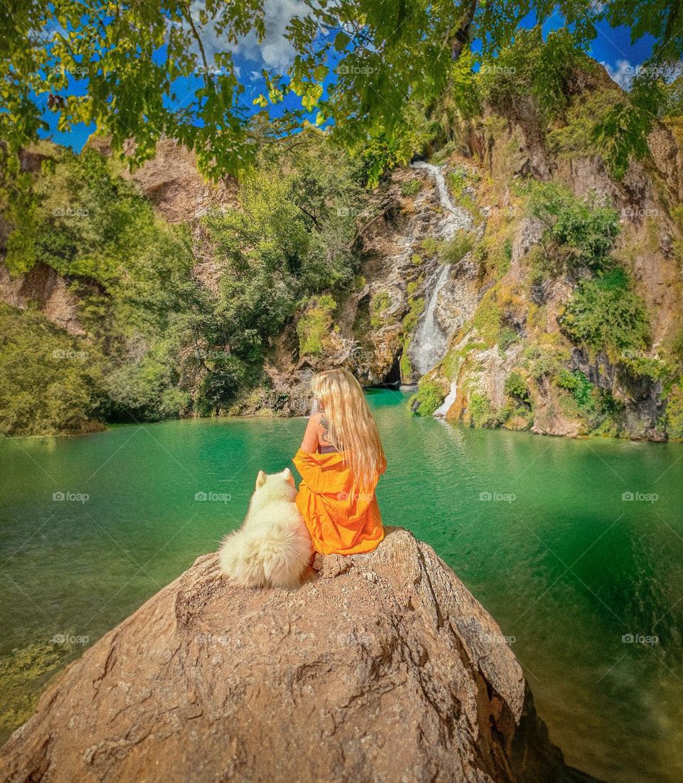 girl and dog looking at the waterfall