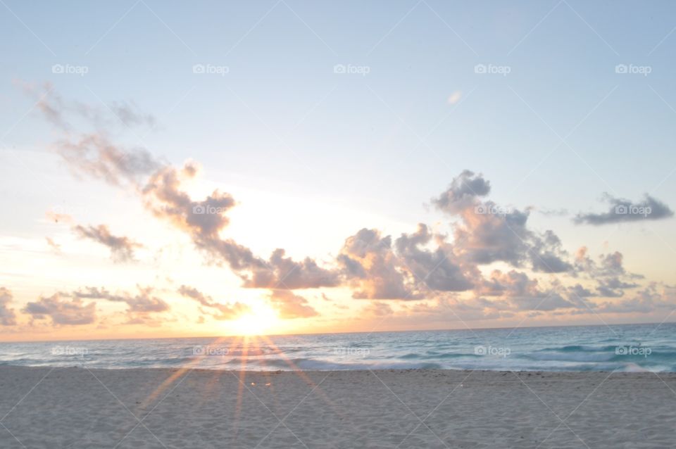 Sun rays at sunrise in Cancun Mexico 