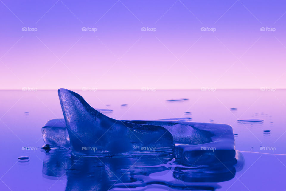 Iceberg and water drops on a mirror surface on a smooth background.