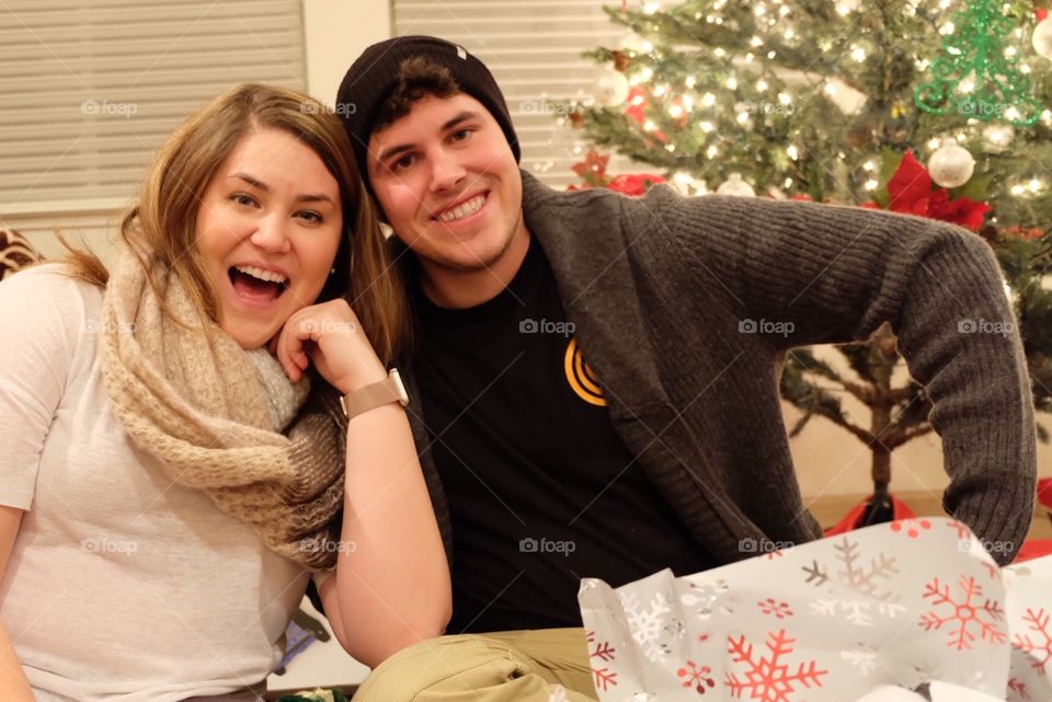 Siblings enjoying opening presents from Santa. 
