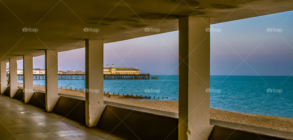 A dusky, sunset view of Hastings pier (pre 2010 fire) and the English Channel, from Bottle Alley in Hastings UK 