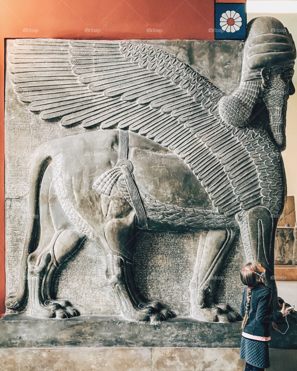 Girl standing near Lamassy in Assyrian chamber at pergamon museum