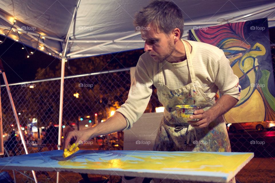 Male artist painting a colorful picture