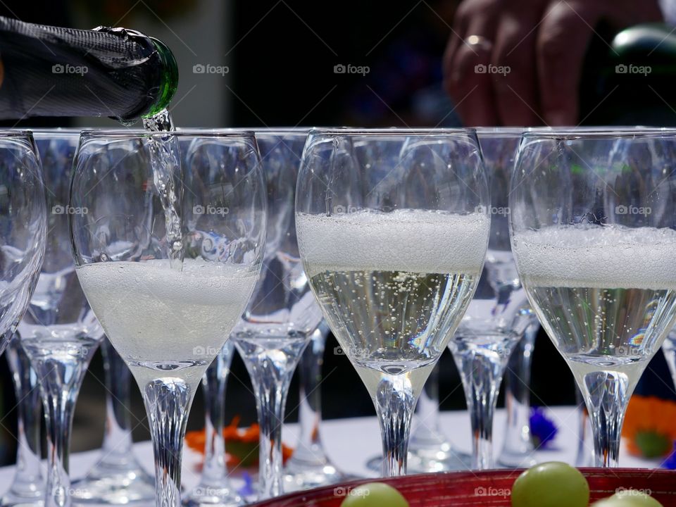 Champagne poured in many glasses wedding ring background
